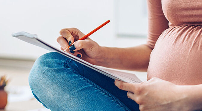 mujer embarazada tomando notas